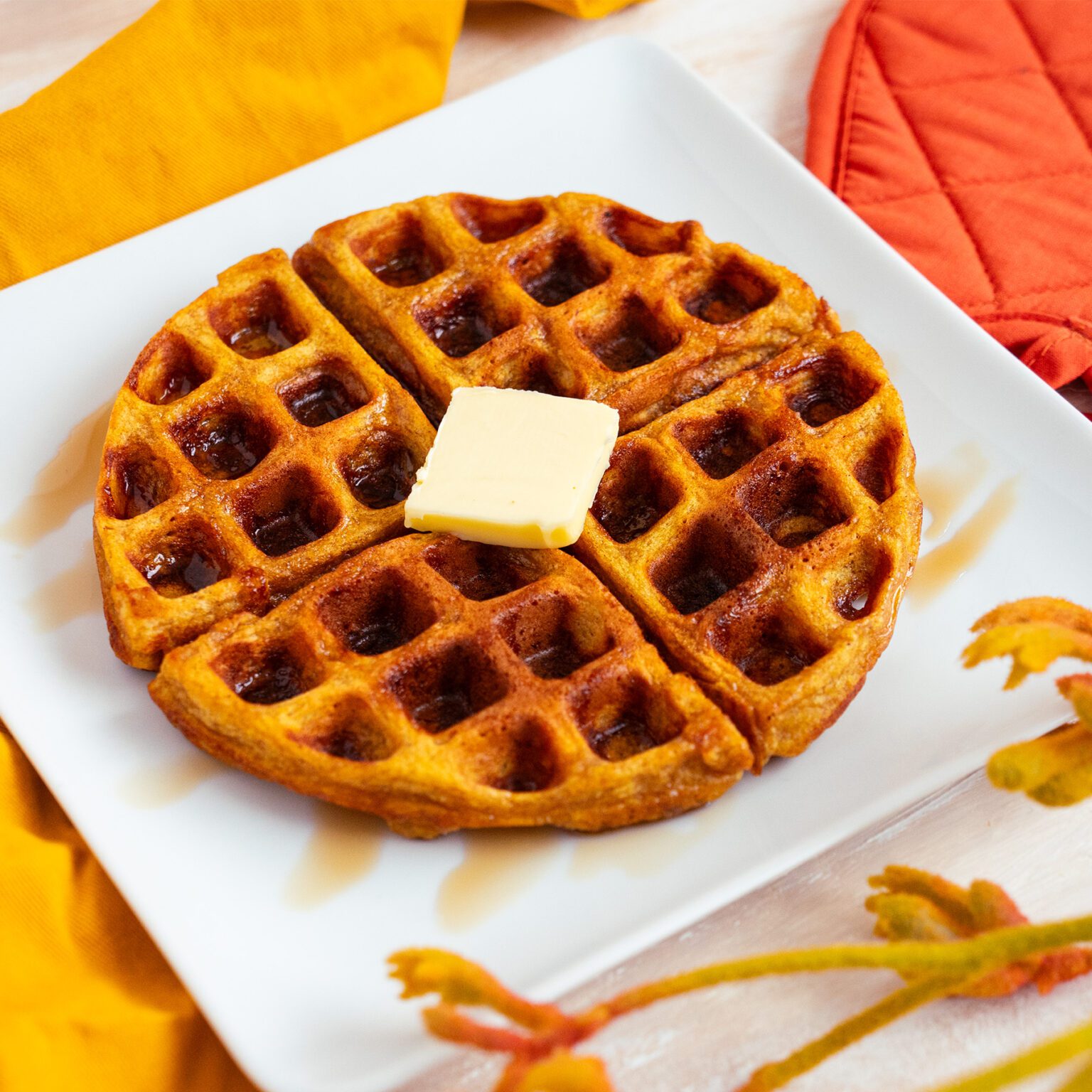 Pumpkin spice waffles with maple syrup and butter